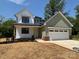 Charming two-story home with white and green siding, a two-car garage, and a well-manicured front yard at 1906 Maius Dr, Conover, NC 28613
