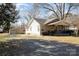 View of home with long driveway and detached garage/storage shed in back at 205 S Pine St, Dallas, NC 28034