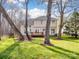 Exterior home view featuring a spacious backyard deck and lush green lawn with mature trees at 227 Tyndale Ct, Waxhaw, NC 28173