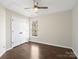 Bright bedroom featuring wood-look floors, a ceiling fan, and a window overlooking a wooded backyard at 227 Tyndale Ct, Waxhaw, NC 28173