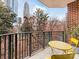 Balcony with bistro seating and a lovely urban view through the trees at 300 W 5Th W St # 407, Charlotte, NC 28202