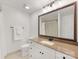 Bright bathroom featuring a granite countertop, white cabinets, and a large framed mirror at 300 W 5Th W St # 407, Charlotte, NC 28202