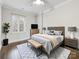 Modern bedroom featuring a ceiling fan, stylish rug, bench, and abundant natural light through a window at 300 W 5Th W St # 407, Charlotte, NC 28202