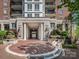 Elegant building entrance with brick and stone accents, featuring manicured landscaping and covered drive-through at 300 W 5Th W St # 407, Charlotte, NC 28202