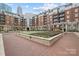Beautiful courtyard featuring a putting green, flowers, brick pavers and surrounding condominium buildings at 300 W 5Th W St # 407, Charlotte, NC 28202