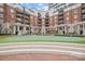 Relax in the well-manicured courtyard featuring a putting green and surrounding condominium buildings at 300 W 5Th W St # 407, Charlotte, NC 28202