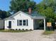 Charming cottage-style home with a manicured lawn, gravel driveway, and a dark green metal roof at 317 Kings Mountain St, York, SC 29745