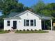 Charming cottage-style home with a manicured lawn, gravel driveway, and a dark green metal roof at 317 Kings Mountain St, York, SC 29745
