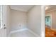 Well-lit laundry room featuring white tile floors, washer/dryer hookups, and an exterior door at 317 Kings Mountain St, York, SC 29745