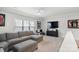 Relaxing bonus room with a plush gray couch, TV, and tasteful decor; perfect for entertainment at 4034 Sagemont Nw Dr, Concord, NC 28027