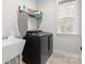 Functional laundry room with modern washer, dryer, sink, and storage shelves at 4034 Sagemont Nw Dr, Concord, NC 28027