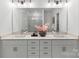 Bright bathroom featuring double sinks, modern fixtures, white marble floors, and a large frameless mirror at 5007 Nimes Rd # 28, Charlotte, NC 28208