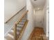 Hallway with a staircase featuring modern black railings and a light wood handrail at 5007 Nimes Rd # 28, Charlotte, NC 28208