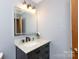Bathroom vanity featuring marble countertop, black faucet, and framed mirror at 5060 Post Oak Ln, Rock Hill, SC 29732