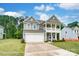 Charming two-story home boasts a covered balcony, attached two-car garage, and manicured lawn at 5116 Heathland Dr # 76, Charlotte, NC 28215