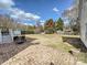 Expansive backyard featuring a brick patio, lush grass, and mature trees, creating a serene outdoor space at 7811 Biddstone Ct, Charlotte, NC 28226