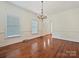 Bright dining room with hardwood floors, a decorative chandelier, and large windows at 7811 Biddstone Ct, Charlotte, NC 28226