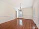 Spacious dining room featuring hardwood floors, a classic chandelier, and white wainscoting at 7811 Biddstone Ct, Charlotte, NC 28226