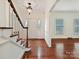 Inviting foyer with hardwood floors, a staircase with a wooden handrail, and transom windows at 7811 Biddstone Ct, Charlotte, NC 28226