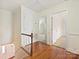 Upstairs hallway with hardwood floors offering views into other carpeted rooms and natural light at 7811 Biddstone Ct, Charlotte, NC 28226
