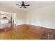 Bright living room featuring hardwood floors and a ceiling fan, flowing into the adjacent modern kitchen at 7811 Biddstone Ct, Charlotte, NC 28226