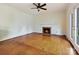 Cozy living room with fireplace and hardwood floors, bathed in natural light from the glass doors at 7811 Biddstone Ct, Charlotte, NC 28226