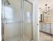 Shower with glass doors, adjacent to an elegant bathroom featuring dual sinks and granite countertop at 7811 Biddstone Ct, Charlotte, NC 28226