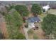 Expansive aerial view of a brick home nestled among mature trees, with a long drive and lake views at 805 Stack Rd, Monroe, NC 28112