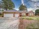 Charming brick home features well-manicured lawn, white shutters, and a spacious three car garage at 805 Stack Rd, Monroe, NC 28112