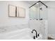 Elegant bathroom showcasing a soaking tub with marble tile surround and black fixtures at 8455 Old Plank Rd, Charlotte, NC 28216