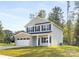 Traditional two-story home featuring a well-manicured lawn, attached garage, and welcoming front porch at 8455 Old Plank Rd, Charlotte, NC 28216