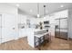 Bright kitchen boasts stainless steel appliances, a quartz countertop island with barstools, and modern cabinetry at 8455 Old Plank Rd, Charlotte, NC 28216