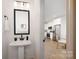 Modern powder room features a sleek pedestal sink and stylish mirror at 8455 Old Plank Rd, Charlotte, NC 28216