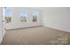 Bright bedroom with carpet, three windows and neutral paint at 9495 Coast Laurel Nw Ave, Concord, NC 28027