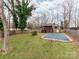 Expansive backyard featuring a closed in-ground pool, large trees, and a grass lawn at 9524 Fairlane Dr, Charlotte, NC 28214