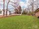 Large backyard with lush lawn, partial fence, and houses in the background at 9524 Fairlane Dr, Charlotte, NC 28214