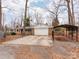 Features a spacious driveway, garage, and carport on an expansive lot with mature trees at 9524 Fairlane Dr, Charlotte, NC 28214