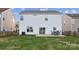 Back of house with patio and table/chairs overlooking a well-maintained backyard at 1102 Less Traveled Trl, Indian Trail, NC 28079