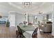 Open-concept dining room area with wooden table and chairs that connects to the living room at 1102 Less Traveled Trl, Indian Trail, NC 28079