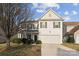 Charming two-story home featuring a pristine white exterior with a two-car garage and a well-manicured front yard at 1102 Less Traveled Trl, Indian Trail, NC 28079