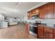 Open kitchen with wood cabinets and stainless steel appliances that connects to the living room at 1102 Less Traveled Trl, Indian Trail, NC 28079