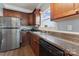 Kitchen sink with wood cabinets and stainless steel refrigerator at 1102 Less Traveled Trl, Indian Trail, NC 28079