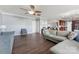 Bright living room features hardwood floors, neutral walls and trim, ceiling fan, and view into the kitchen area at 1102 Less Traveled Trl, Indian Trail, NC 28079