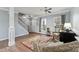 Elegant living room featuring hardwood floors, neutral wall colors, large windows, and a staircase at 1102 Less Traveled Trl, Indian Trail, NC 28079