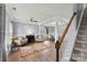 Elegant living room featuring hardwood floors, neutral wall colors, and staircase access to dining room at 1102 Less Traveled Trl, Indian Trail, NC 28079