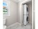 Bright bathroom with marble floors, a stacked washer and dryer, and a modern toilet at 1205 Poston Cir, Gastonia, NC 28054