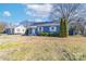 Charming blue single-story home with a manicured lawn, white trim, and an American flag at 1205 Poston Cir, Gastonia, NC 28054