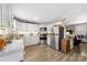 Open kitchen with white cabinets, stainless steel appliances, and adjacent living area at 1205 Poston Cir, Gastonia, NC 28054