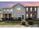 Charming townhomes showcasing colorful siding, brick accents and well-maintained landscaping at sunset at 128 Locomotive Ln # 110, Mooresville, NC 28115