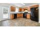 Well-lit kitchen features wooden cabinets, black appliances, and tile flooring at 128 Locomotive Ln # 110, Mooresville, NC 28115